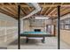 Unfinished basement with exposed wood ceiling beams, stone fireplace and pool table at 3588 Sw Highridge Dr, Conyers, GA 30094