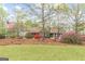 Well-maintained front yard with mature trees and vibrant azaleas at 3588 Sw Highridge Dr, Conyers, GA 30094