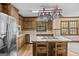 Well-lit kitchen with wooden cabinets, a stainless steel fridge, an island and hanging pot rack at 3588 Sw Highridge Dr, Conyers, GA 30094
