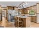 Well-lit kitchen with wooden cabinets, a stainless steel fridge, and an island with seating at 3588 Sw Highridge Dr, Conyers, GA 30094