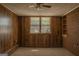 Bedroom with wood paneling, brick wall, carpet flooring, window and ceiling fan at 5183 Jones Ct, Morrow, GA 30260