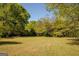 Large grassy backyard with mature trees, providing a serene and private outdoor space at 5183 Jones Ct, Morrow, GA 30260