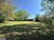 Large grassy backyard with mature trees, providing a serene and private outdoor space at 5183 Jones Ct, Morrow, GA 30260