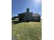 Back exterior featuring a covered patio, spacious yard, and grey siding at 935 S Laney Rd, Locust Grove, GA 30248