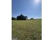Back exterior featuring a covered patio, spacious yard, and grey siding at 935 S Laney Rd, Locust Grove, GA 30248