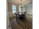 Elegant dining room featuring hardwood floors, wainscoting, a chandelier, and a view of the outside at 935 S Laney Rd, Locust Grove, GA 30248