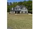 Charming two-story home with gray siding, black shutters, and a well-manicured lawn surrounded by lush green trees at 935 S Laney Rd, Locust Grove, GA 30248