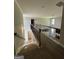 Hallway with carpeted floor, a wooden railing, and view of the living room below at 935 S Laney Rd, Locust Grove, GA 30248
