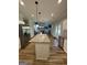 Stylish kitchen island with granite countertops, pendant lighting, and stainless steel appliances overlooking the living room at 935 S Laney Rd, Locust Grove, GA 30248