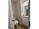 Modern powder room features a toilet, sink, mirror, and ample space at 935 S Laney Rd, Locust Grove, GA 30248