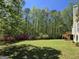 A lush, green backyard with a small storage shed bordered by vibrant azaleas at 210 Sweetwater Dr, Fayetteville, GA 30214