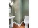 Elegant powder room with a pedestal sink, decorative mirror, and striped wallpaper at 210 Sweetwater Dr, Fayetteville, GA 30214