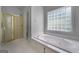 Relaxing bathroom featuring a luxurious jetted tub, a separate shower, and a block window at 210 Sweetwater Dr, Fayetteville, GA 30214