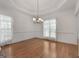 Dining room featuring wood floors, neutral walls, a stylish chandelier, and large windows at 210 Sweetwater Dr, Fayetteville, GA 30214