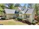 Beautiful home exterior with lush landscaping, dark shutters, and a charming stone and stucco facade at 210 Sweetwater Dr, Fayetteville, GA 30214