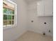 Functional laundry room with white cabinets, wire shelving, and a bright window at 210 Sweetwater Dr, Fayetteville, GA 30214