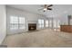 Bright living room featuring a brick fireplace, large windows, and a ceiling fan at 210 Sweetwater Dr, Fayetteville, GA 30214