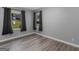 Bedroom with neutral walls, and wood-look flooring, featuring windows dressed with dark curtains at 2903 Monterey Dr, Decatur, GA 30032