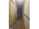 Hallway with neutral carpet and walls, showcasing the home's layout and flow between rooms at 6183 Field Stone Dr, Douglasville, GA 30134