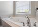 Close-up of bathroom with a large soaking tub and chrome water fixture at 2060 Dixie Rd, Covington, GA 30014