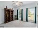 Sunlit bedroom featuring two large windows, an elegant bookcase and a ceiling fan at 2060 Dixie Rd, Covington, GA 30014