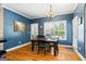 Dining room with hardwood floors, blue walls, and a view of the backyard swimming pool at 2060 Dixie Rd, Covington, GA 30014