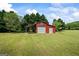 The red barn on this property features a covered area, and two garage doors at 2060 Dixie Rd, Covington, GA 30014