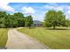 Long driveway leading to a brick home set back on a large manicured lawn and mature trees at 2060 Dixie Rd, Covington, GA 30014