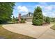 View of a home with a large driveway and attached garage, surrounded by mature trees at 2060 Dixie Rd, Covington, GA 30014