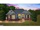 Charming brick home with manicured lawn and landscape lighting and a welcoming front porch at 2060 Dixie Rd, Covington, GA 30014