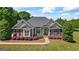 Charming brick home with manicured lawn and landscape lighting and a welcoming front porch at 2060 Dixie Rd, Covington, GA 30014