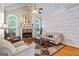 Cozy living room with a brick fireplace, wood floors, and plenty of natural light from large windows at 2060 Dixie Rd, Covington, GA 30014