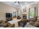 Inviting living room with fireplace, neutral carpet, crown molding, and large windows overlooking the backyard pool at 2060 Dixie Rd, Covington, GA 30014