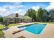 Backyard oasis featuring a sparkling pool, spacious patio, and a comfortable swing chair for relaxation at 2060 Dixie Rd, Covington, GA 30014