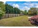 Fenced backyard featuring well-maintained lawn, mature trees, and landscaping at 424 N Green Cir, Mcdonough, GA 30252