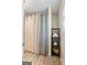 Well-lit bathroom featuring a shower with a stylish curtain and a convenient shelving unit for towels and toiletries at 424 N Green Cir, Mcdonough, GA 30252