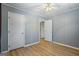 Neutral bedroom featuring wood-look floors, pale blue paint, and two white doors for a clean design at 424 N Green Cir, Mcdonough, GA 30252