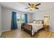 Light-filled bedroom featuring a ceiling fan, wood-look floors, a large bed, and an exterior view through two windows at 424 N Green Cir, Mcdonough, GA 30252