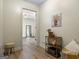 Inviting hallway with hardwood floors, a decorative table with warm lighting and a view to a bedroom through an open doorway at 424 N Green Cir, Mcdonough, GA 30252