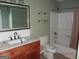 Bathroom showcasing a wood vanity, framed mirror, new floors, and a tub and shower combination at 2338 Rambling Way, Lithonia, GA 30058