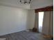This bedroom features light wood flooring, neutral walls, and a window with curtains at 2338 Rambling Way, Lithonia, GA 30058