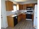 Bright kitchen features white subway tile backsplash, light wood cabinets, and black appliances at 2338 Rambling Way, Lithonia, GA 30058