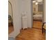 Hallway leading to a carpeted bedroom with blue and white bedding and wood floors at 6127 Floyd Ne St, Covington, GA 30014