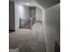Upstairs hallway with neutral carpet, grey walls and trim, and access to additional rooms at 6127 Floyd Ne St, Covington, GA 30014