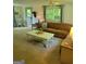A cozy living room featuring soft carpet, natural light, and a comfortable brown sofa at 6127 Floyd Ne St, Covington, GA 30014