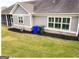 A well-maintained backyard with lush grass, a stone foundation, and practical trash bins at 1598 Renaissance Ne Dr, Conyers, GA 30012