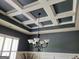 Sophisticated coffered ceiling design with modern chandelier fixture in an elegant dining room at 1598 Renaissance Ne Dr, Conyers, GA 30012
