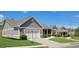 A well kept house features an attached two car garage and nicely landscaped yard at 1598 Renaissance Ne Dr, Conyers, GA 30012