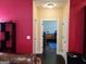 Hallway view showing bedroom with blue accents from living room featuring bright colored walls at 1598 Renaissance Ne Dr, Conyers, GA 30012