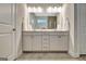 Bright bathroom featuring dual sinks, white cabinets and drawers, decorative mirror and tiled floor at 609 Francis Ave, Peachtree City, GA 30269